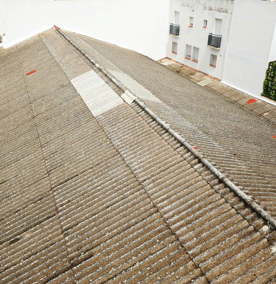 Weathered asbestos roof sheeting on an older building