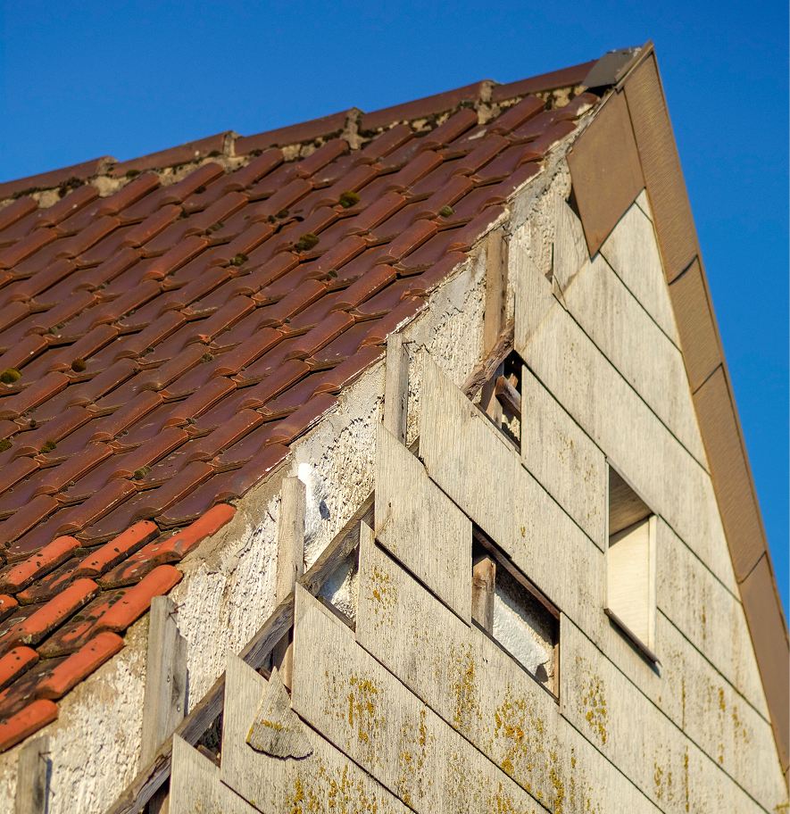 Old exterior wall cladding undergoing asbestos testing inspection