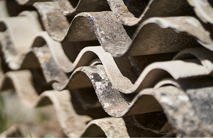 Close-up of deteriorating roofing tile being tested for asbestos content