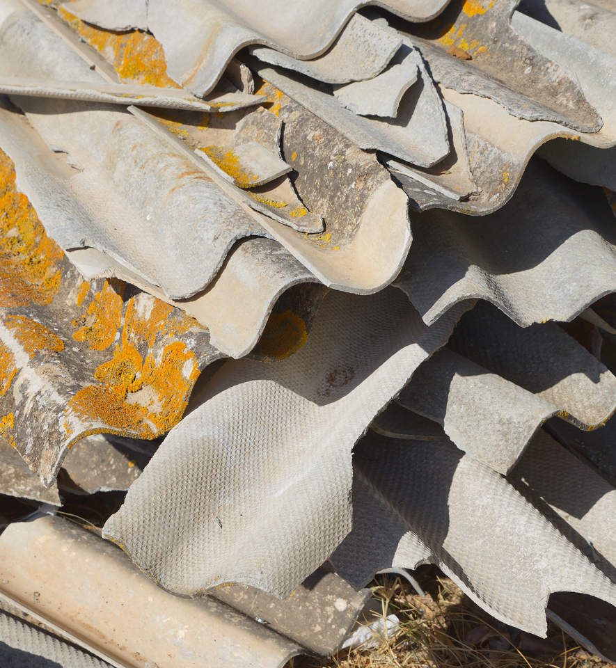 Construction worker handling asbestos-containing materials at demolition site