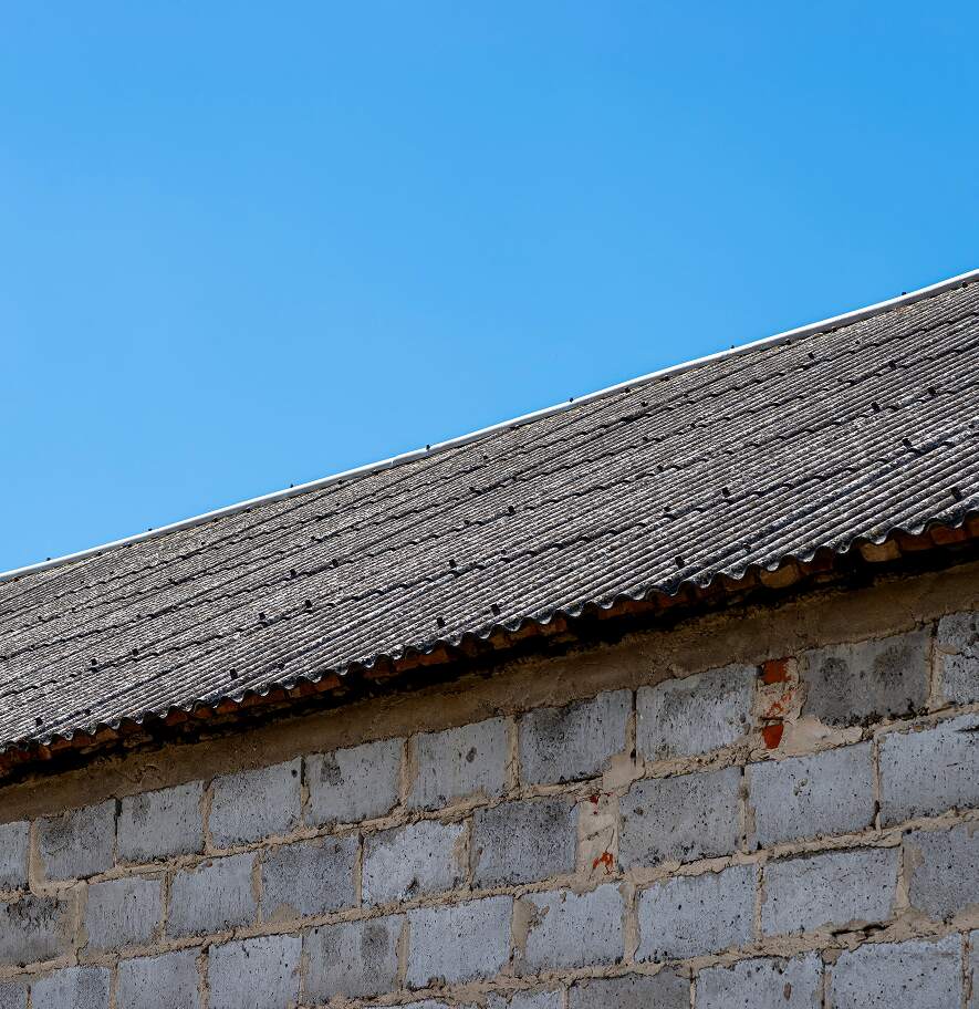 Blue asbestos cement roofing panels on an older structure